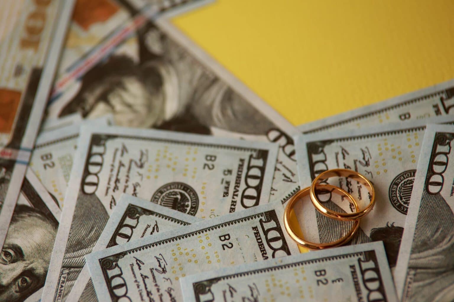 wedding-rings-atop-one-hundred-dollar-bills